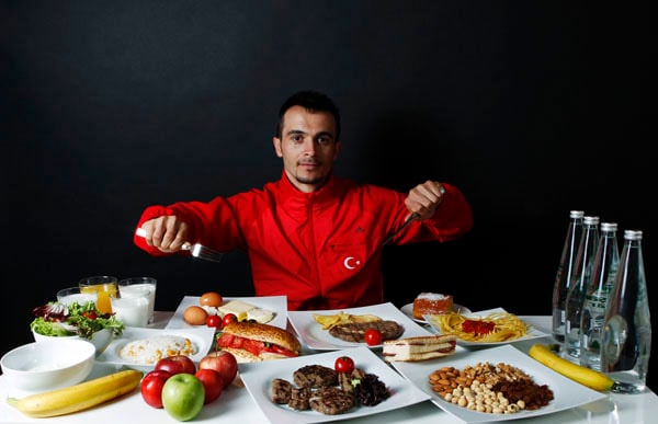 Turkish weightlifter and Olympic hopeful Mete Binay poses in front of his daily meal intake in Ankara